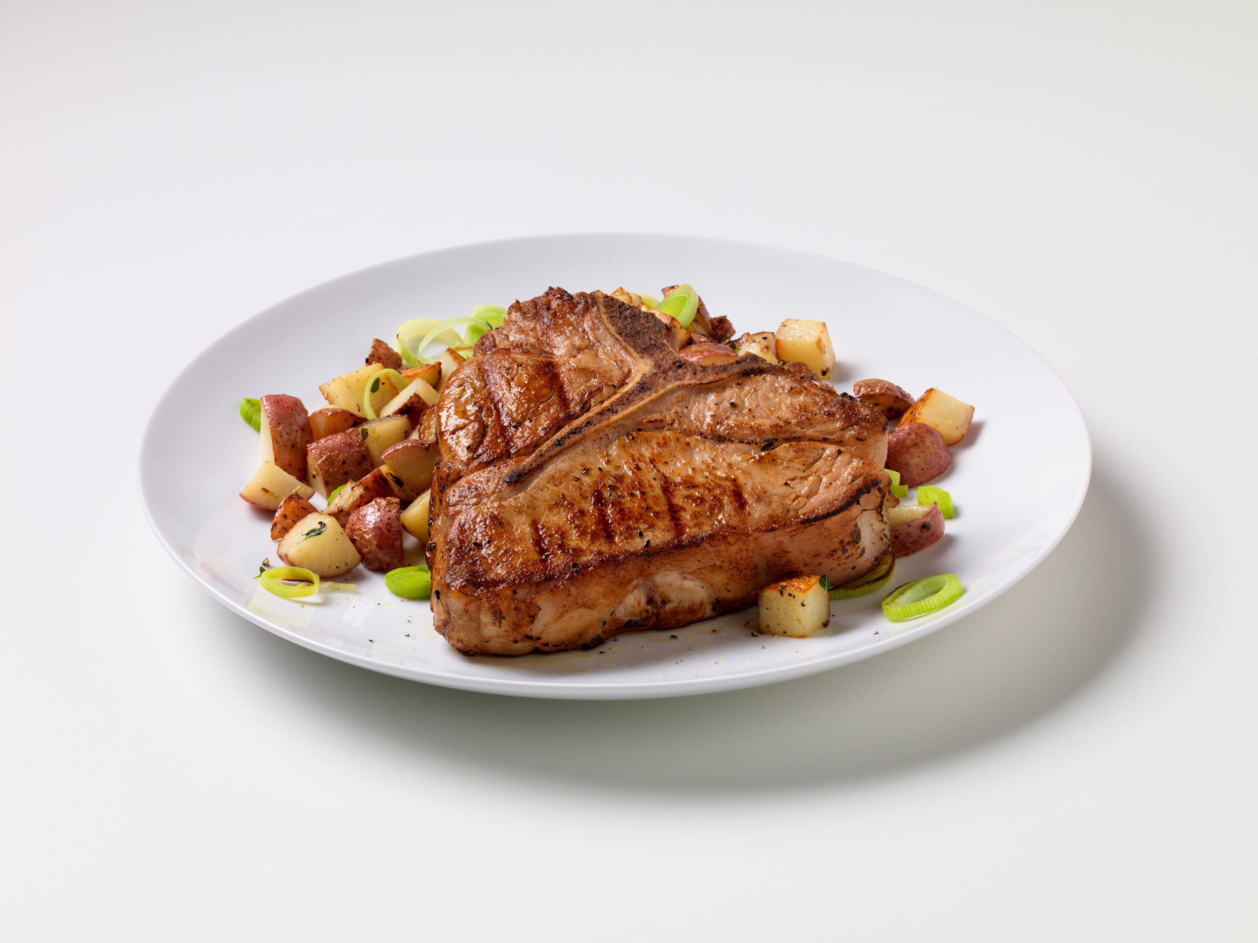 Grilled veal chops, t-bones, with potato leek hoash