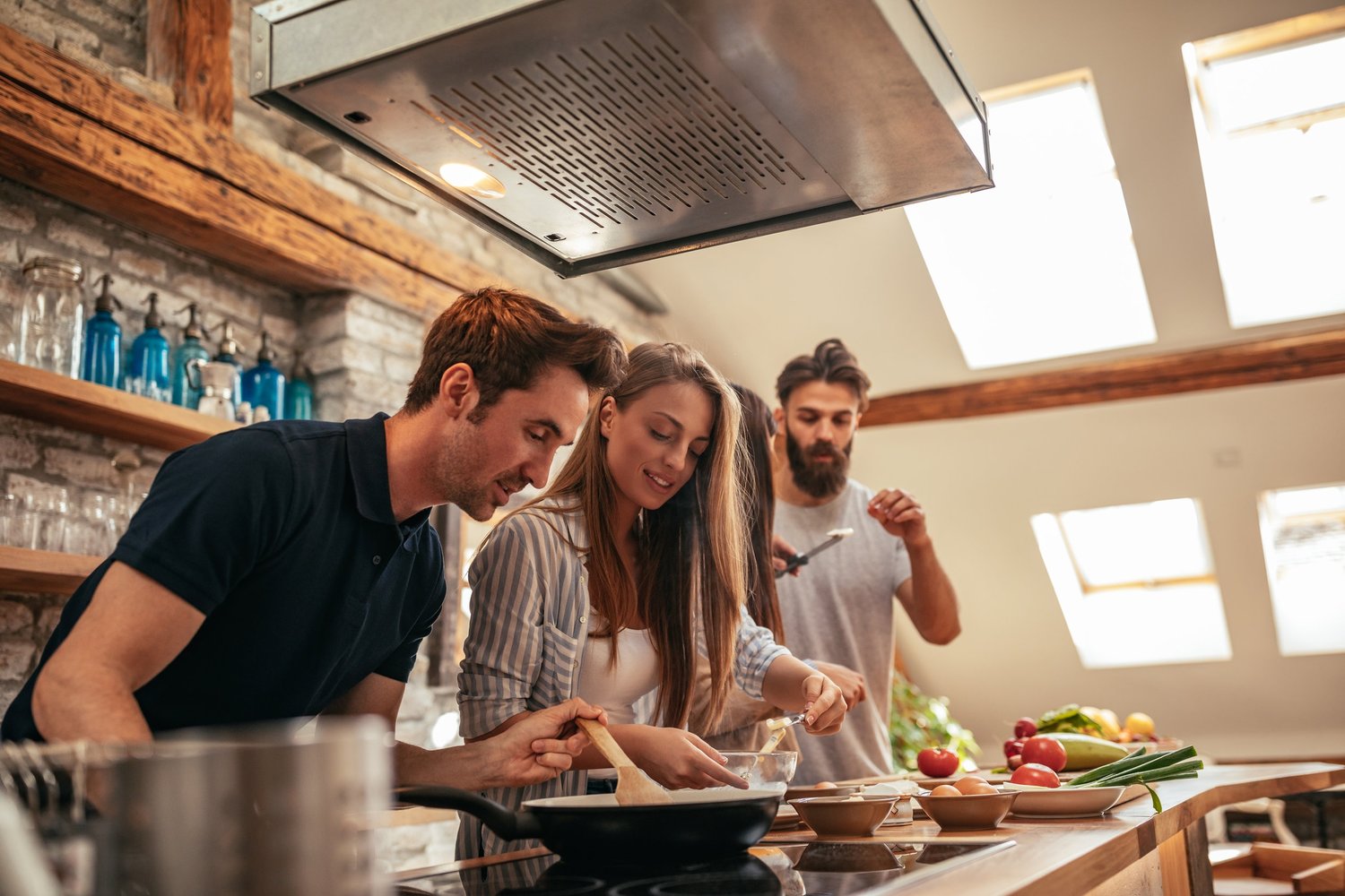 four people cooking in the kitchen