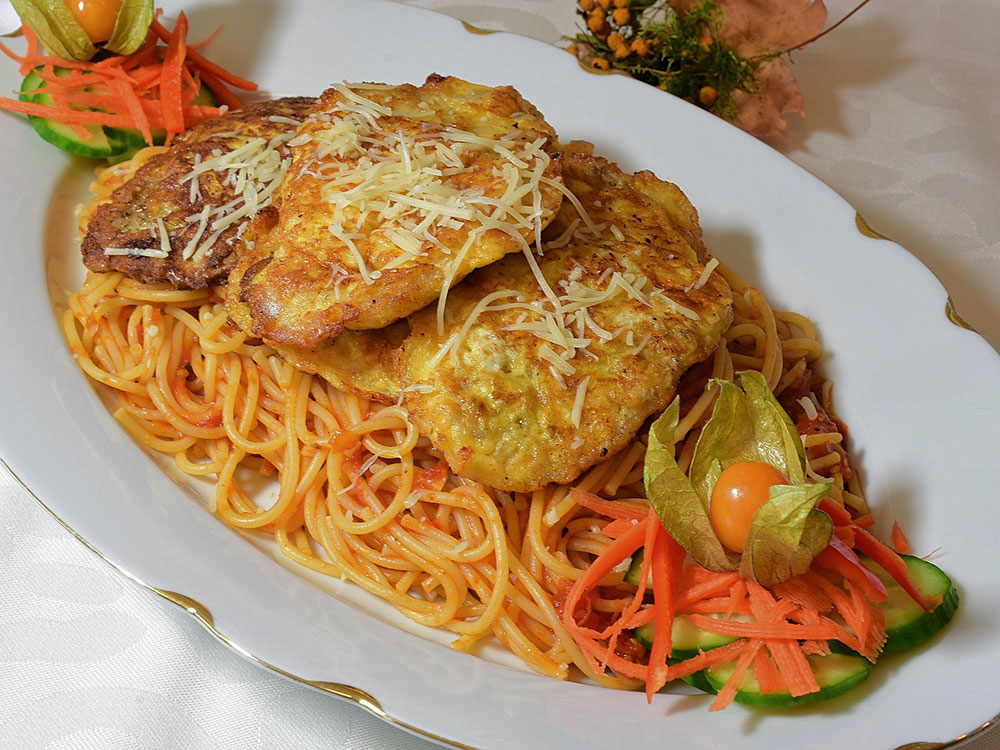 Piccata Milanese on bed of noodles and carrot/cucumber garnish