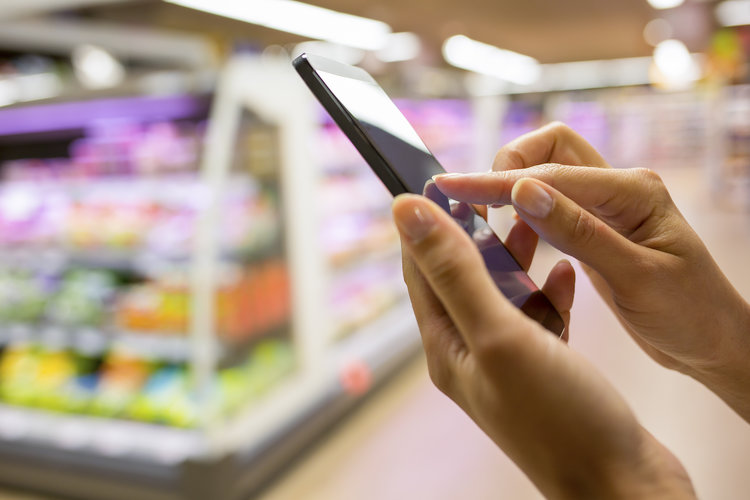 Cell phone in hand at store stock image