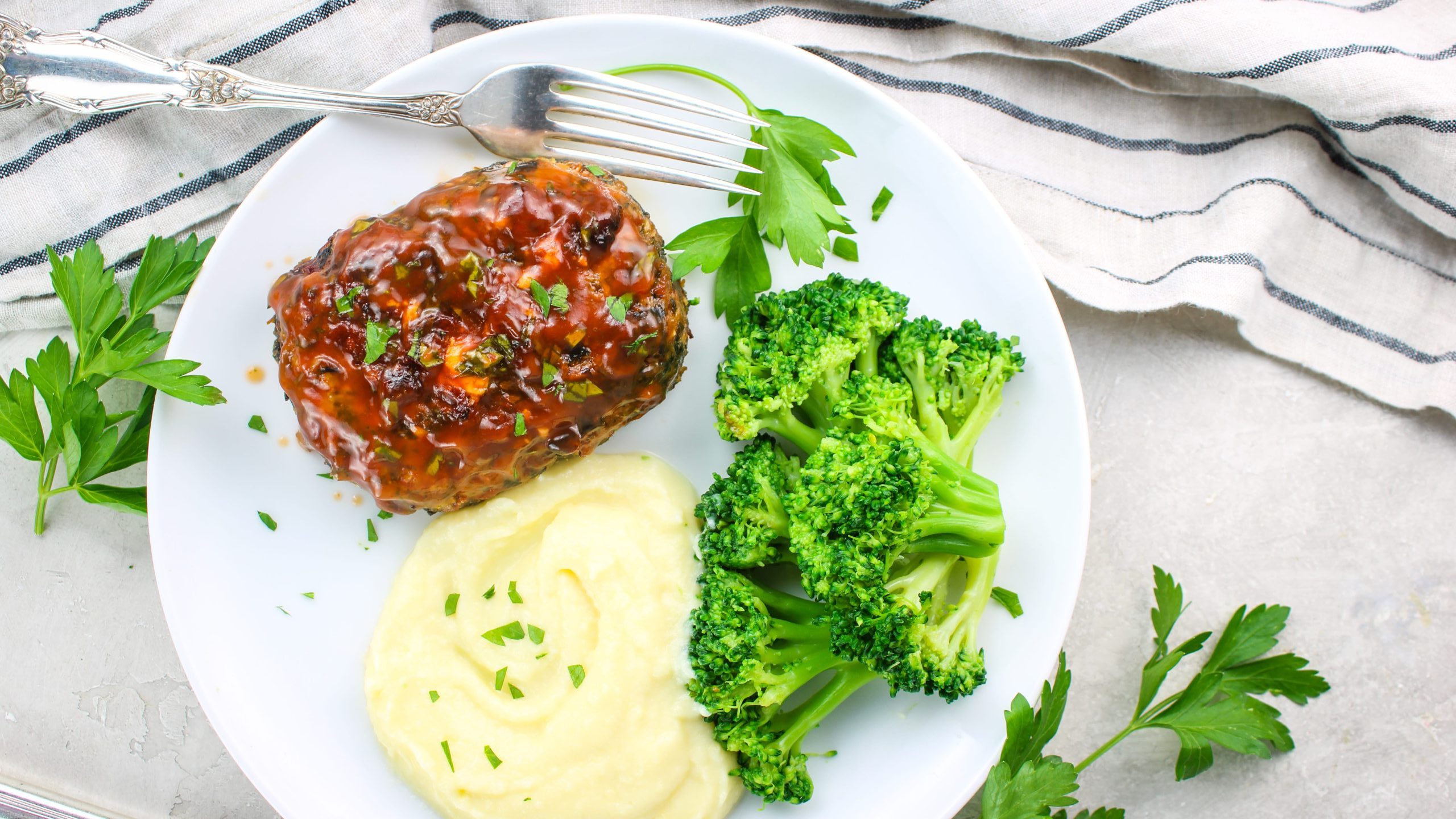 Spinach and Feta Mini Meatloaves are served with mashed potatoes and steamed broccoli