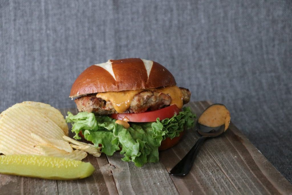 This Bacon burger packs a secret ingredient of potato chips served with fresh greens, tomato, onion, and a special burger sauce.