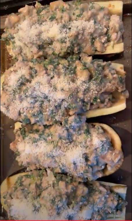 ground veal stuffed eggplants cut in half and served with grated parmesan cheese on top.