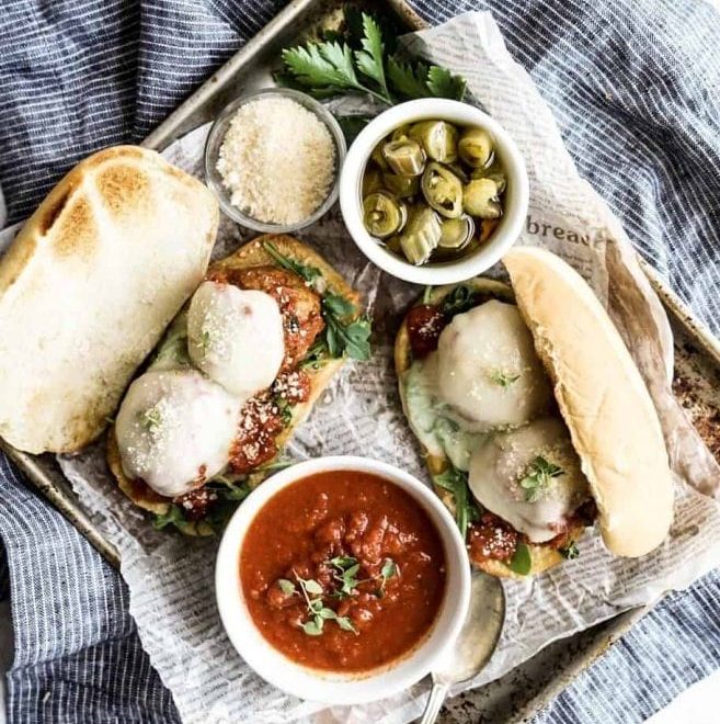 Thick meatballs subs served on toasted hoagie roll with melted mozzarella sauce, and basil.