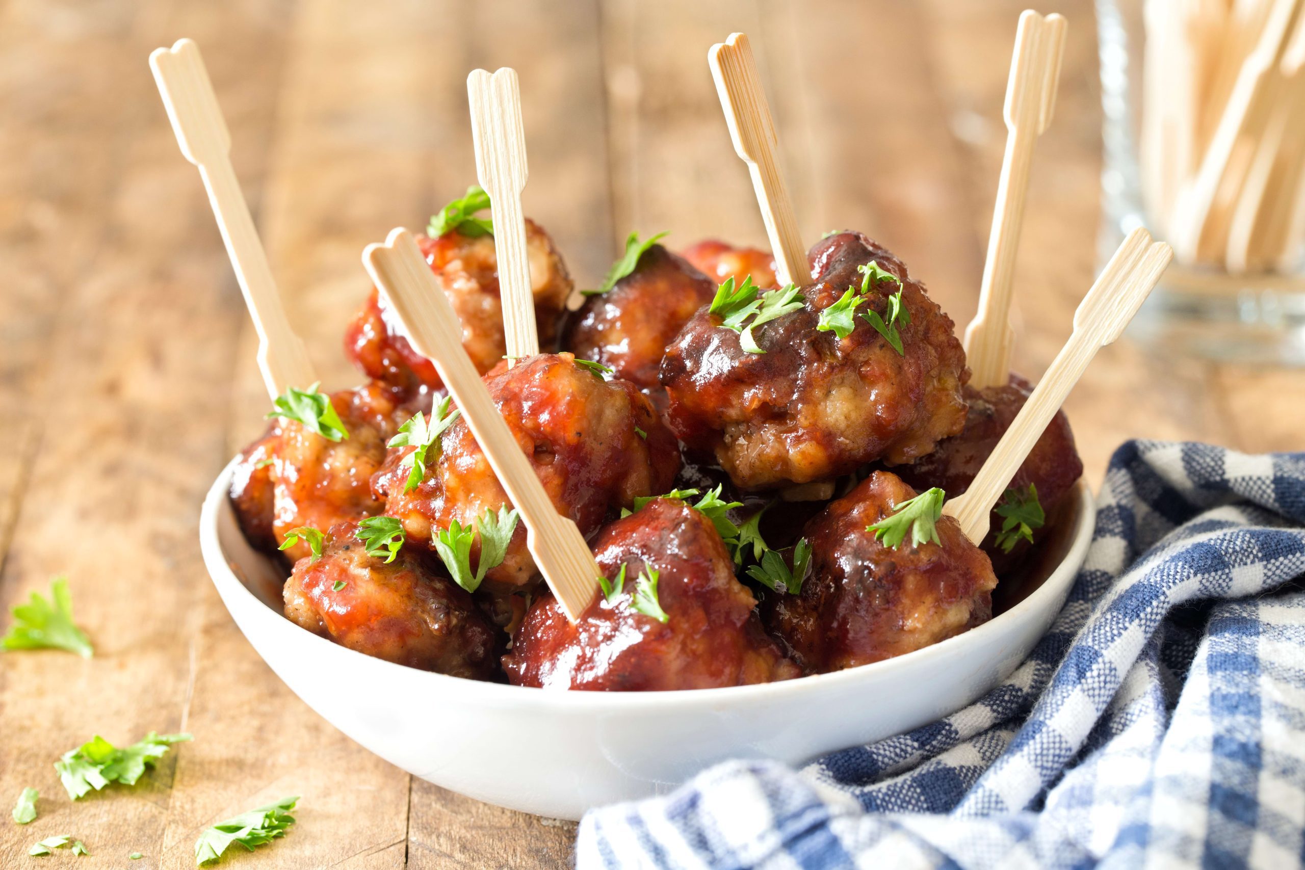 Chili Meatballs in a white bowl with toothpicks to serve as a finger food or serving dish.