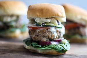 Mini Greek Sliders are finger food sized and bursting with flavor from the spinach, red onion, tomato, cucumber, feta cheese, and tzatziki.