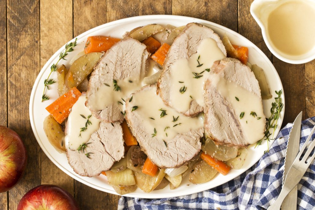 Autumn Veal Roast with Apples, Thyme, and Carrots sliced and served on bed of potatoes and carrots